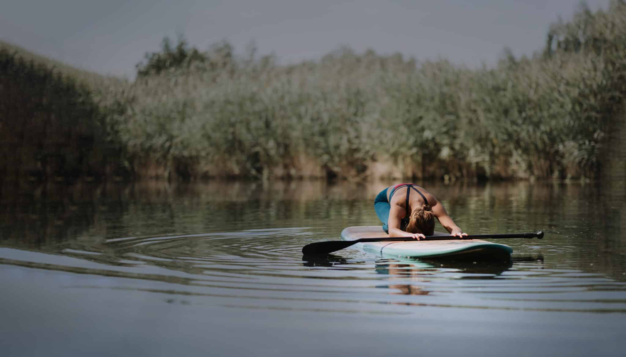 Woman Practicing Yoga On Paddle Board