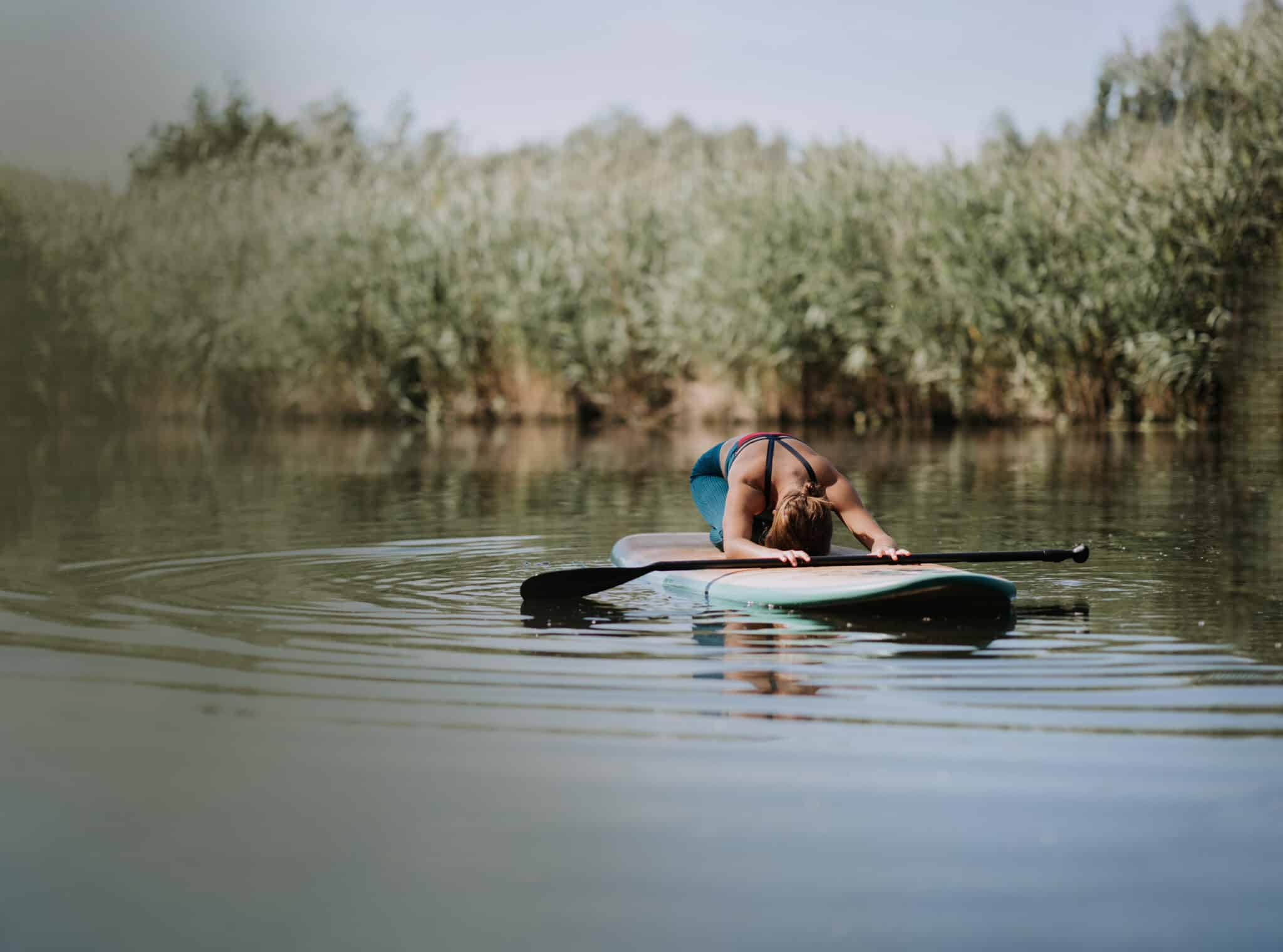 Woman Practicing Yoga On Paddleboard