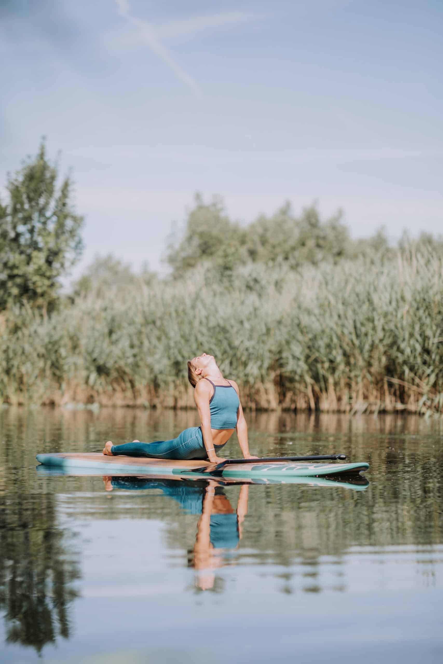 Woman Practicing Yoga On Paddleboard