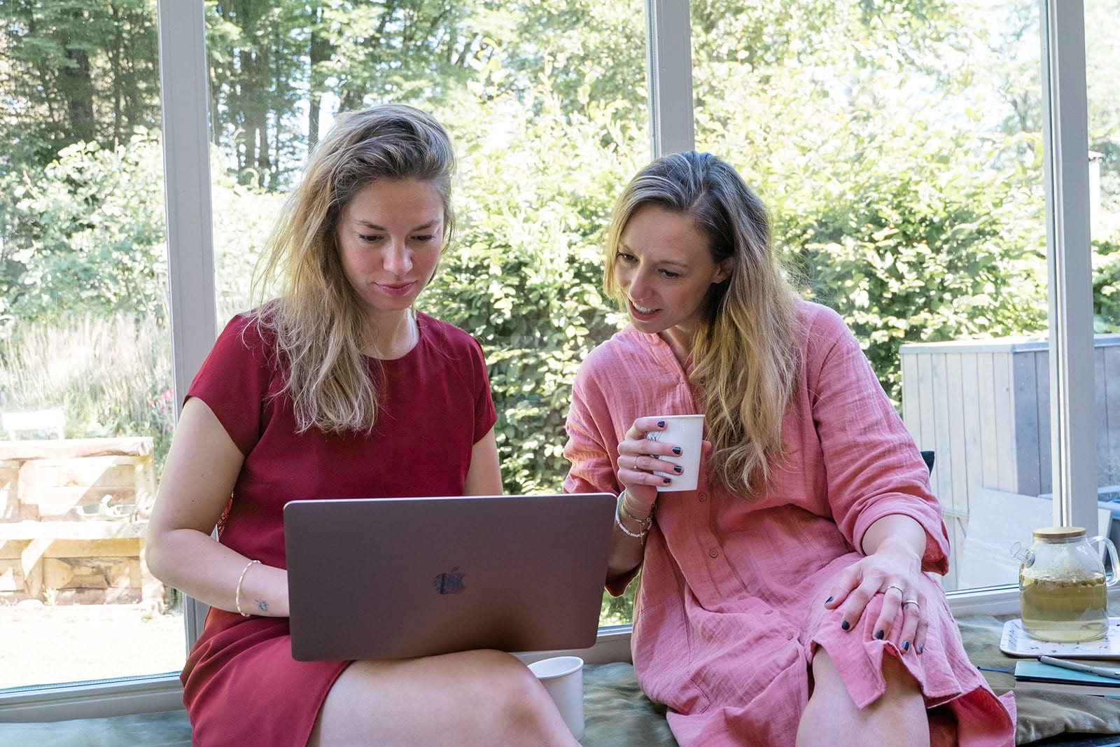 Two Women Collaborating On Laptop Indoors