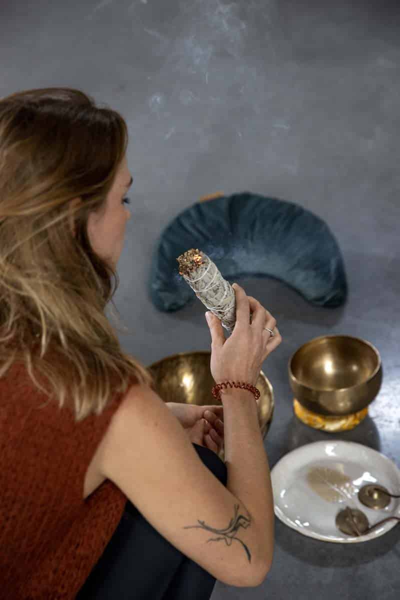Woman Holding Burning Sage With Singing Bowls