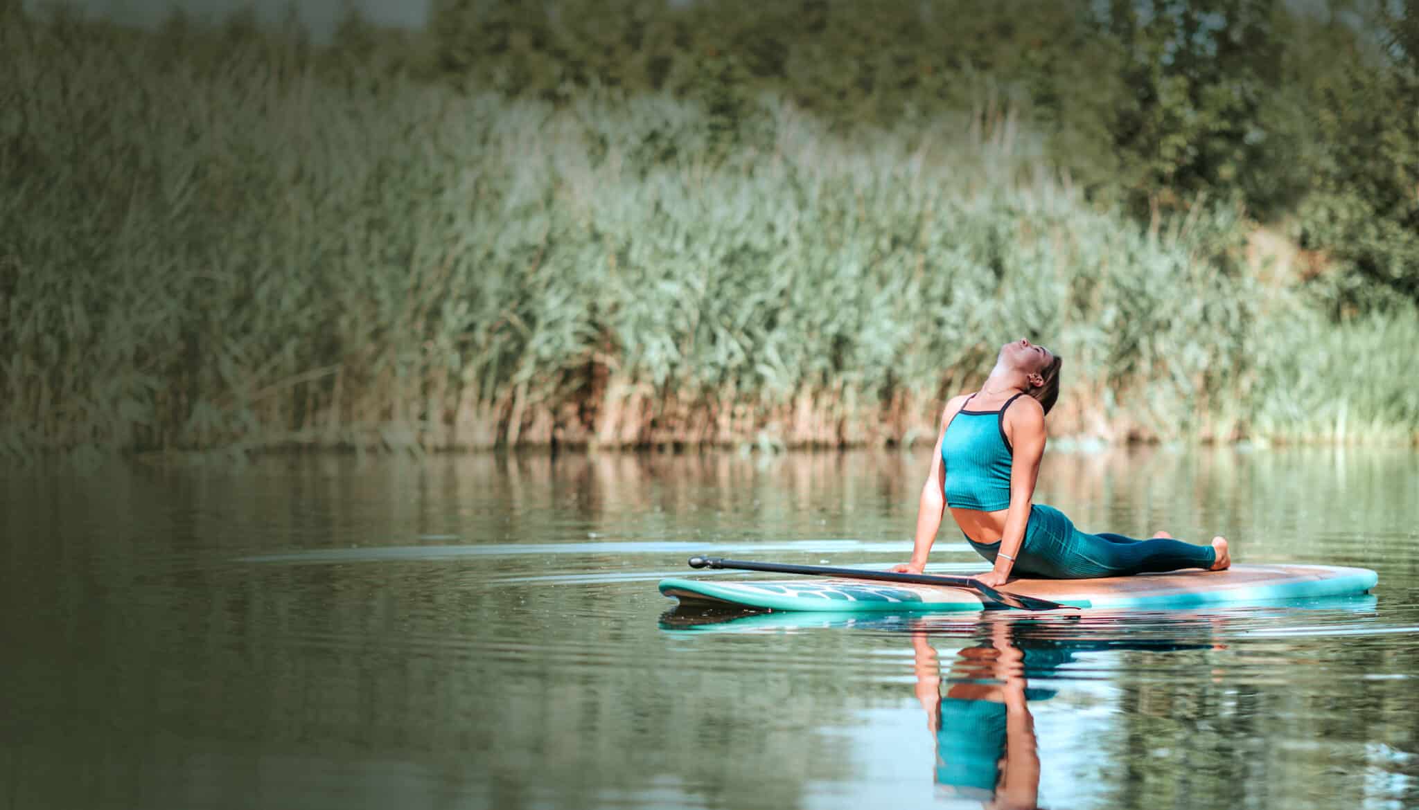Woman Practicing Yoga On Paddle Board