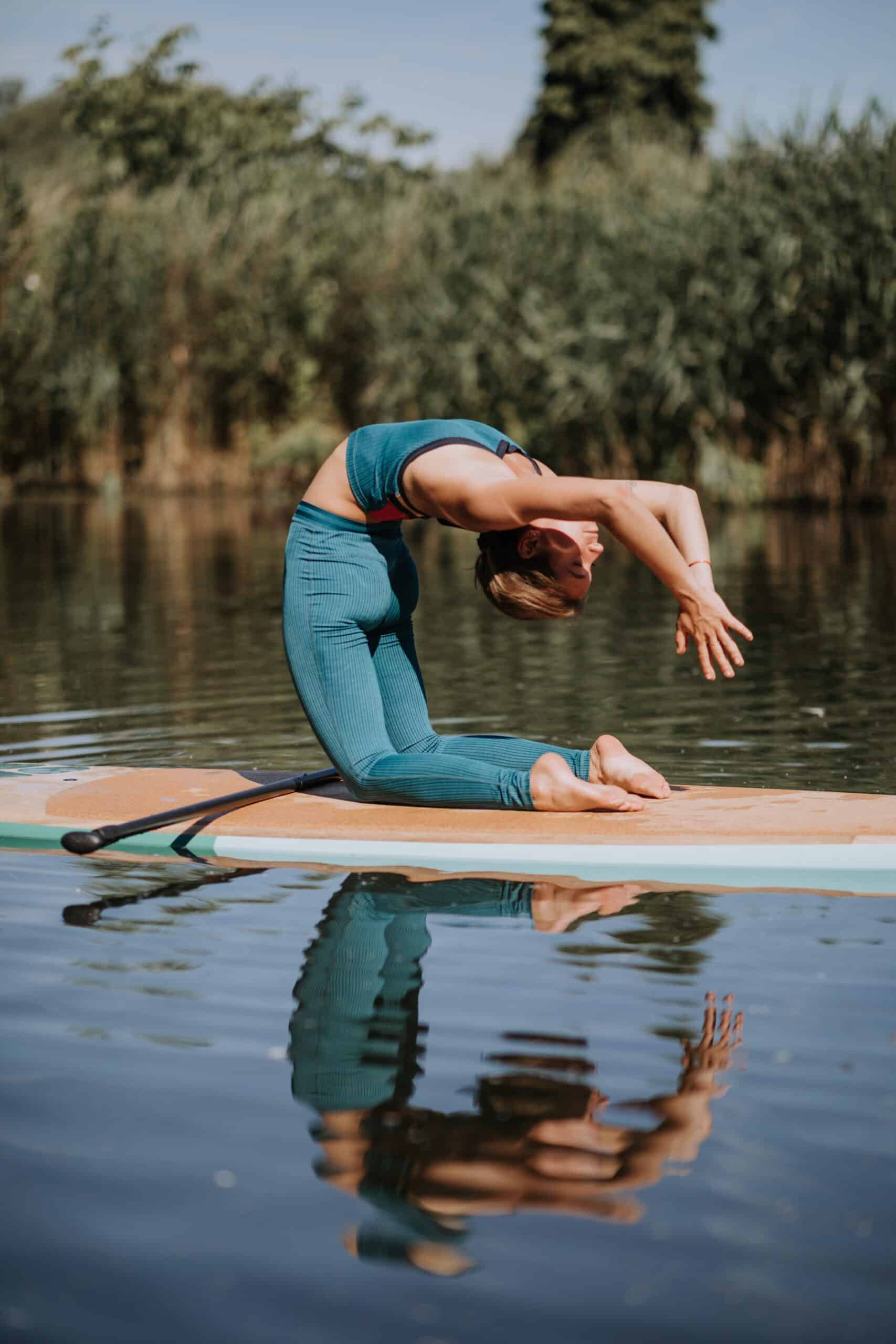 Woman Practicing Yoga On Paddle Board