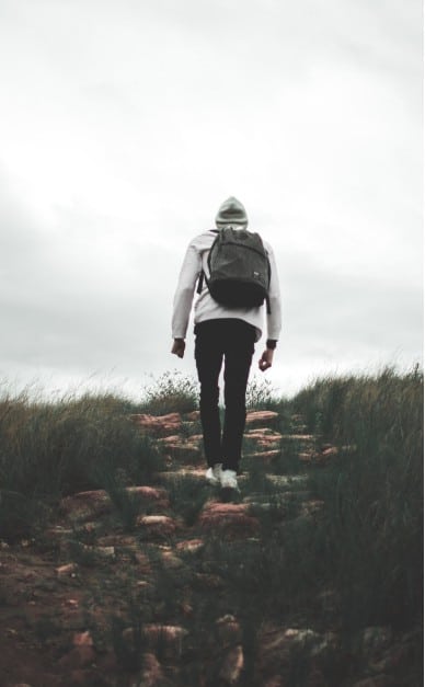 Hiker Walking Up A Rocky Path