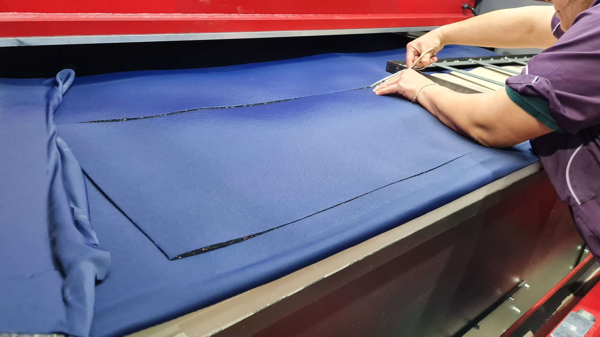 A Person Cutting Blue Yoga Mat Fabric