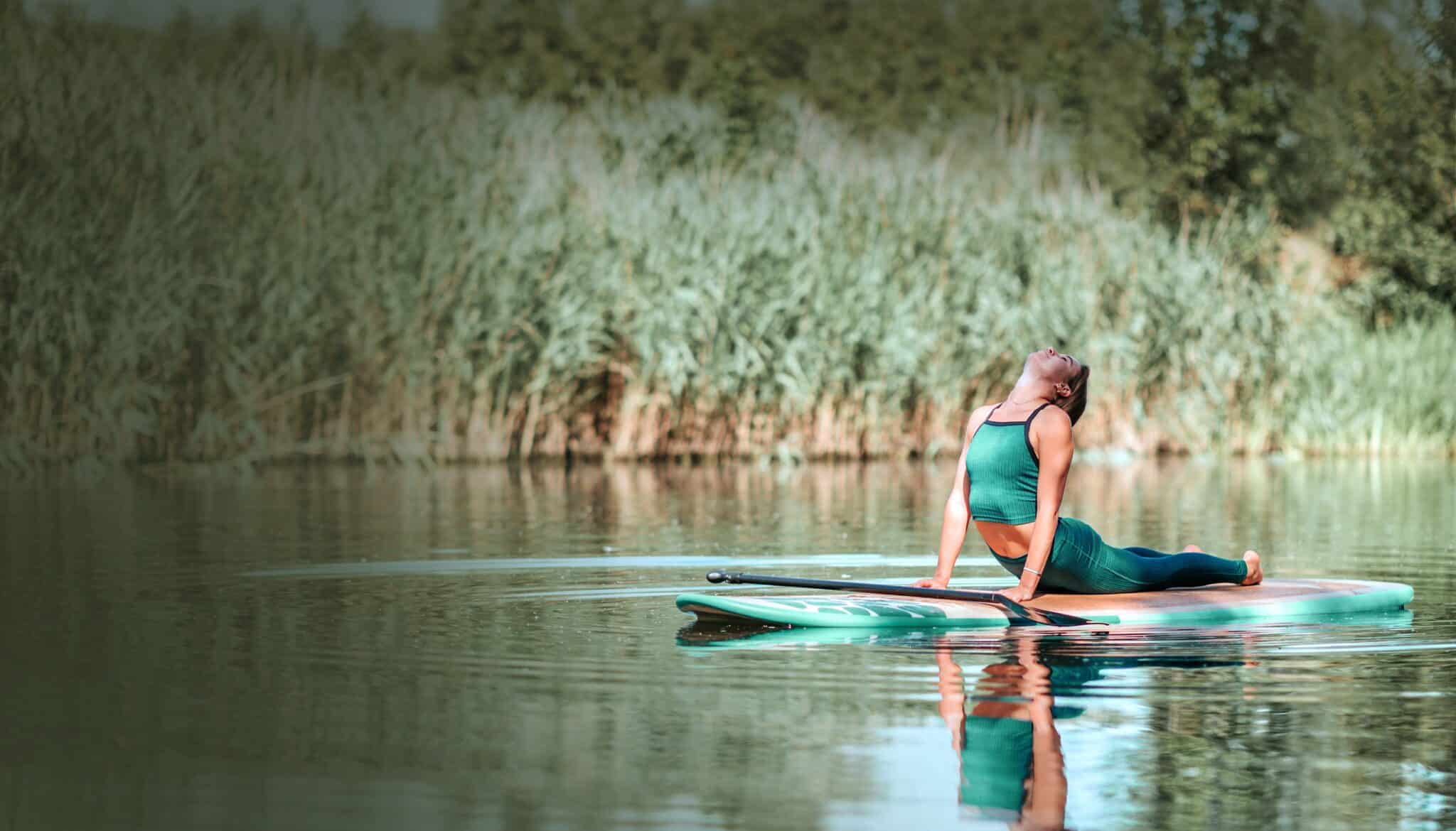 Woman Practicing Yoga On Paddle Board