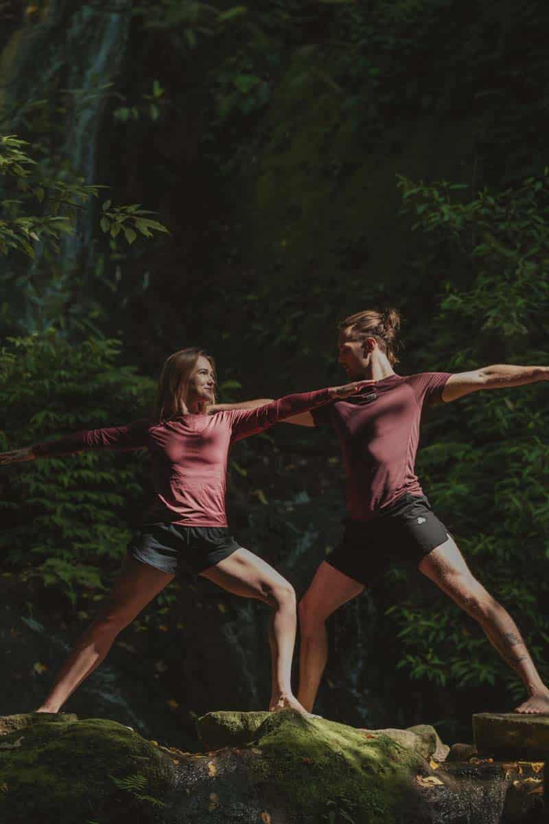 People Practicing Warrior Two Yoga Pose Outdoors