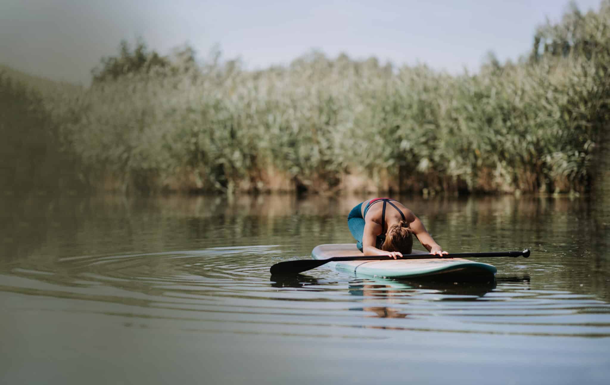 Woman Practicing Yoga On Paddle Board