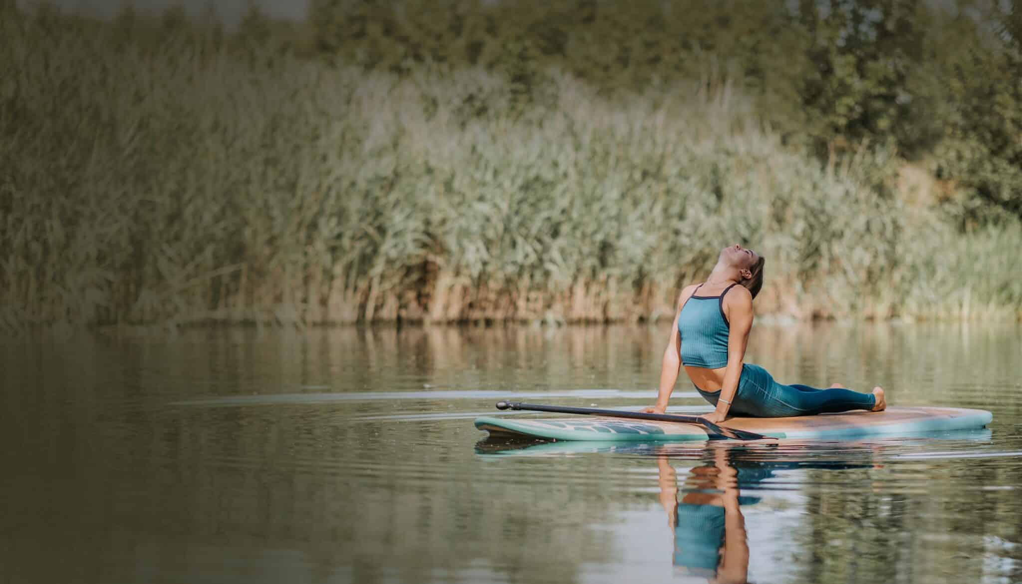 Woman Practicing Yoga On Paddleboard