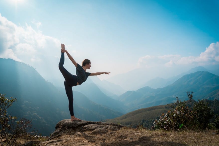 Woman Practicing Yoga In The Mountains