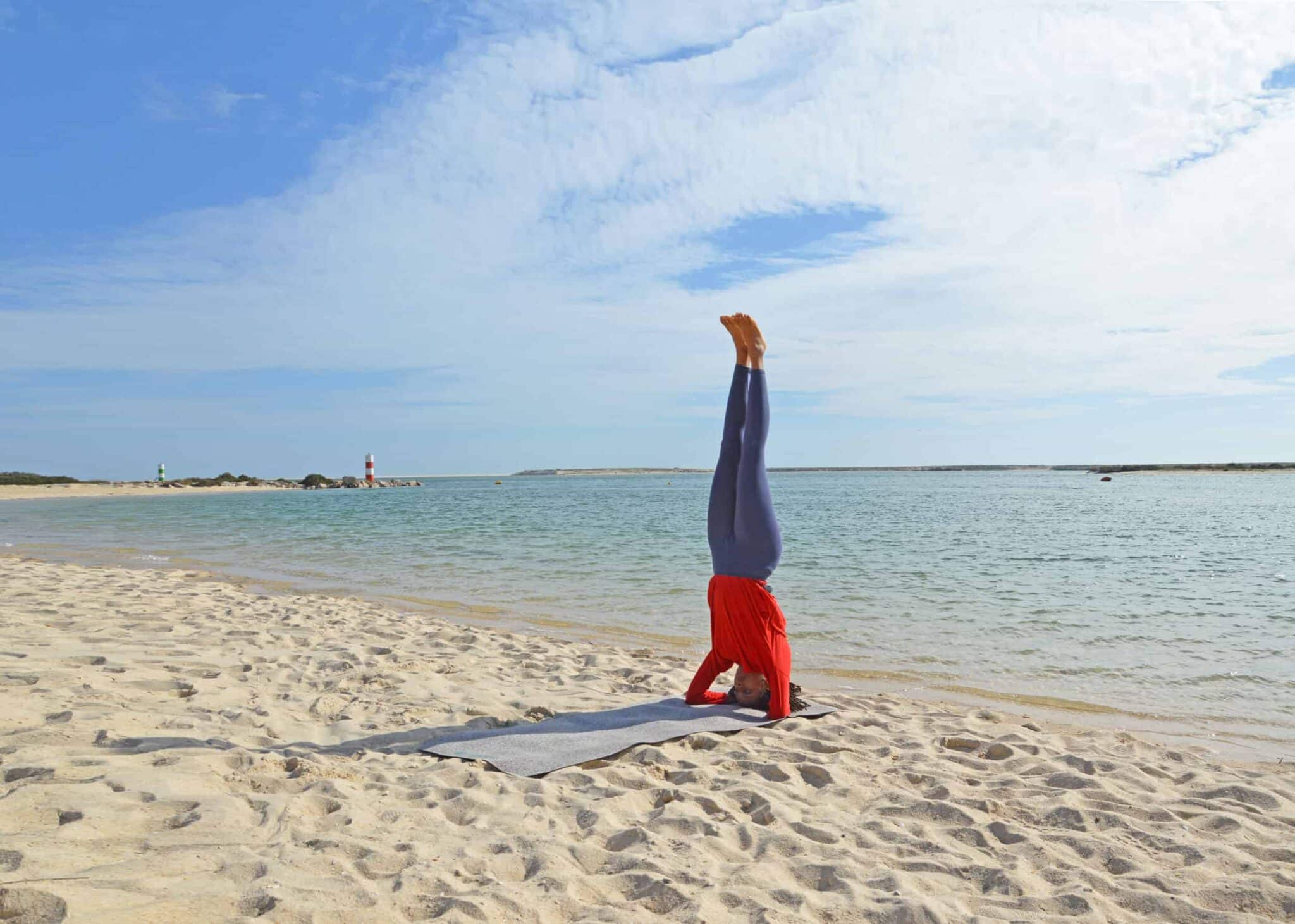 Woman Doing Headstand On Beach Yoga Mat