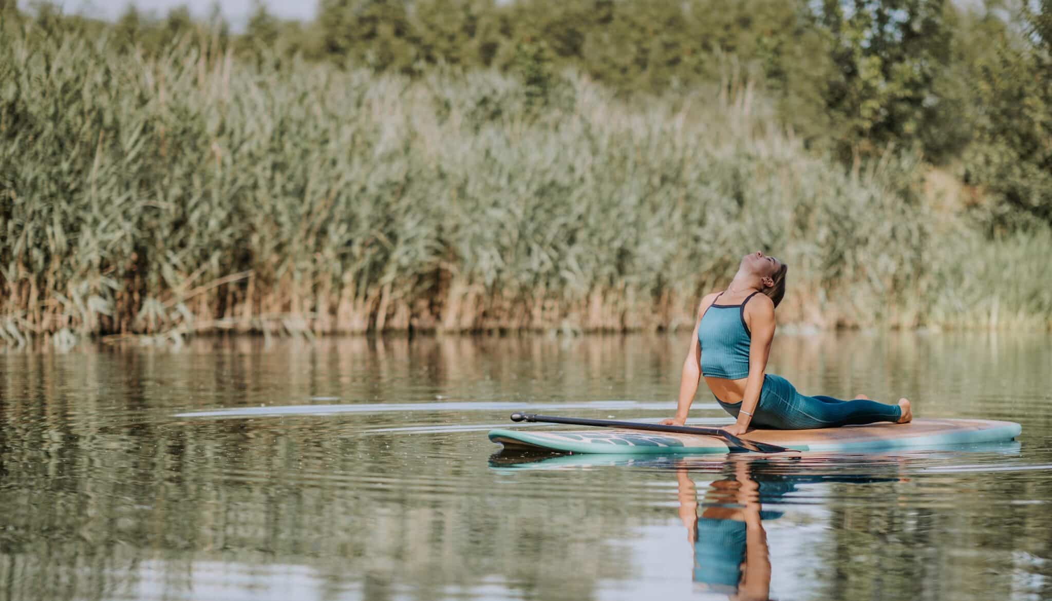 Woman Practicing Yoga On Paddleboard