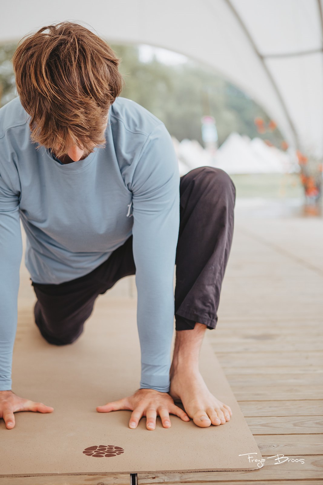 Man practising on a cork yoga mat on an outdoor deck