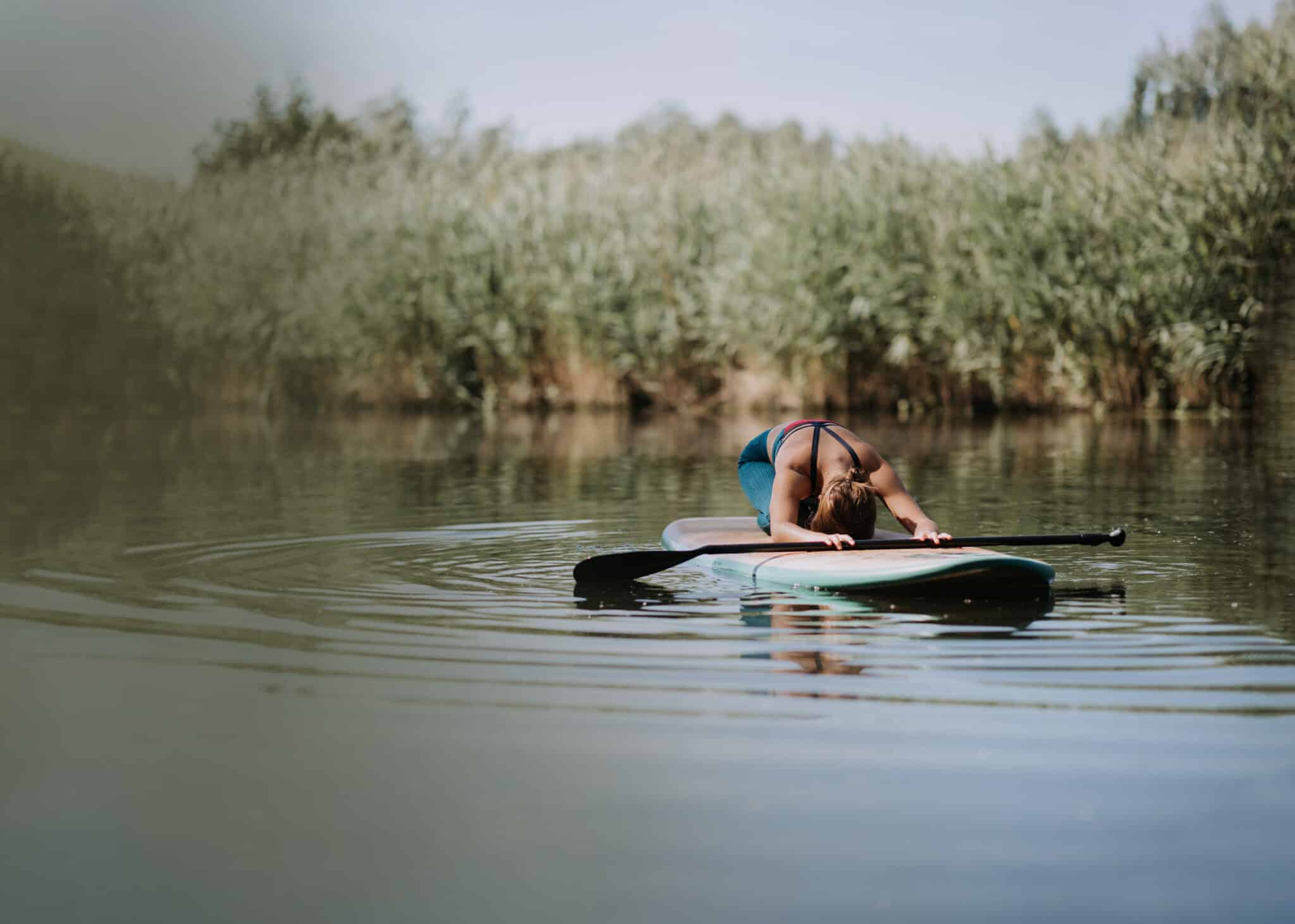 Woman Stretching on Paddle Board