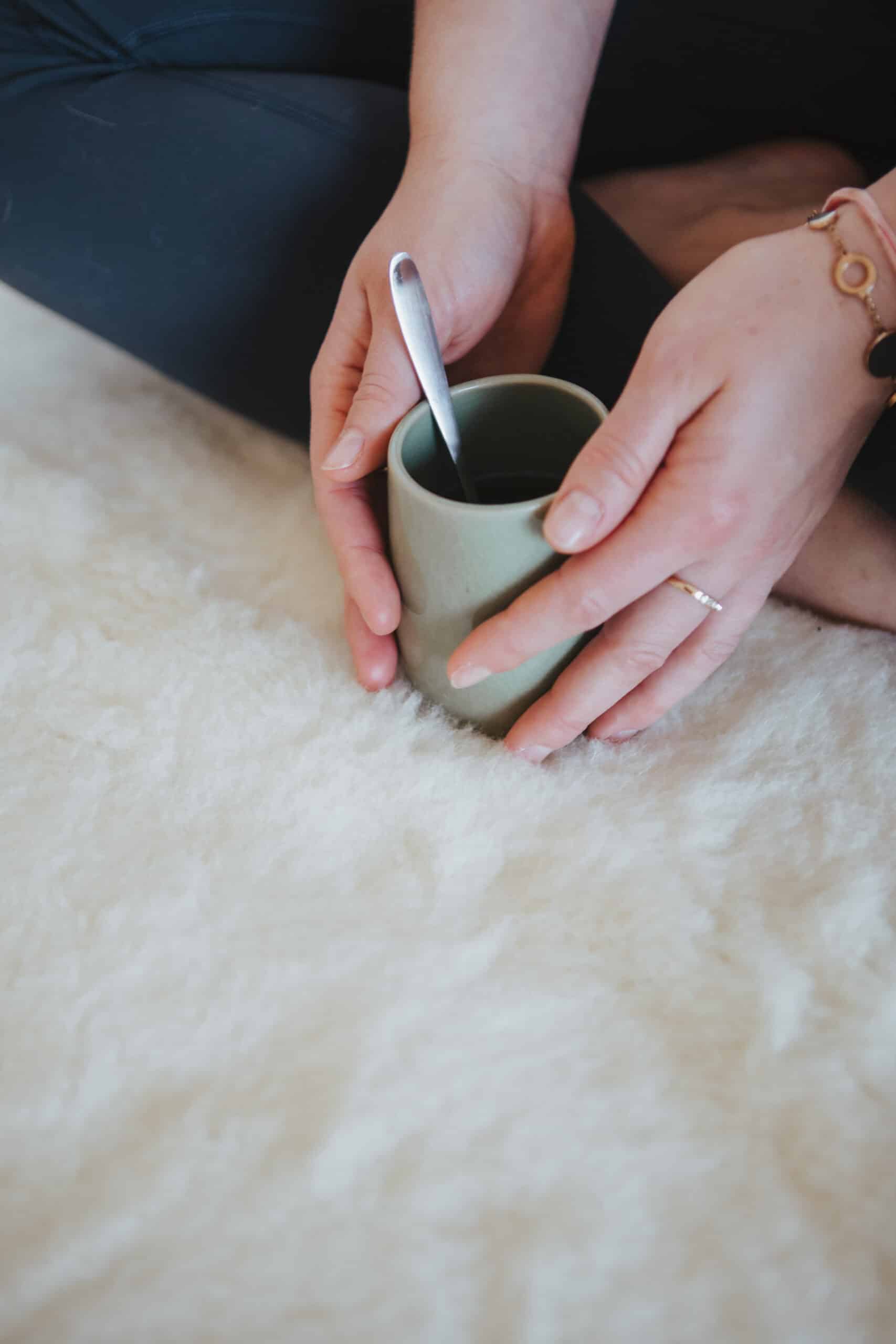 Woman Holding Cup On Soft Wool Rug