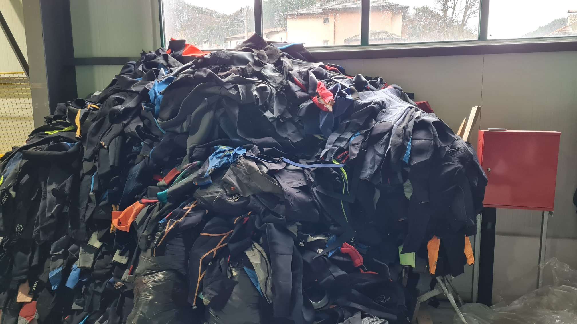 Large Pile Of Recycled Neoprene Wetsuits