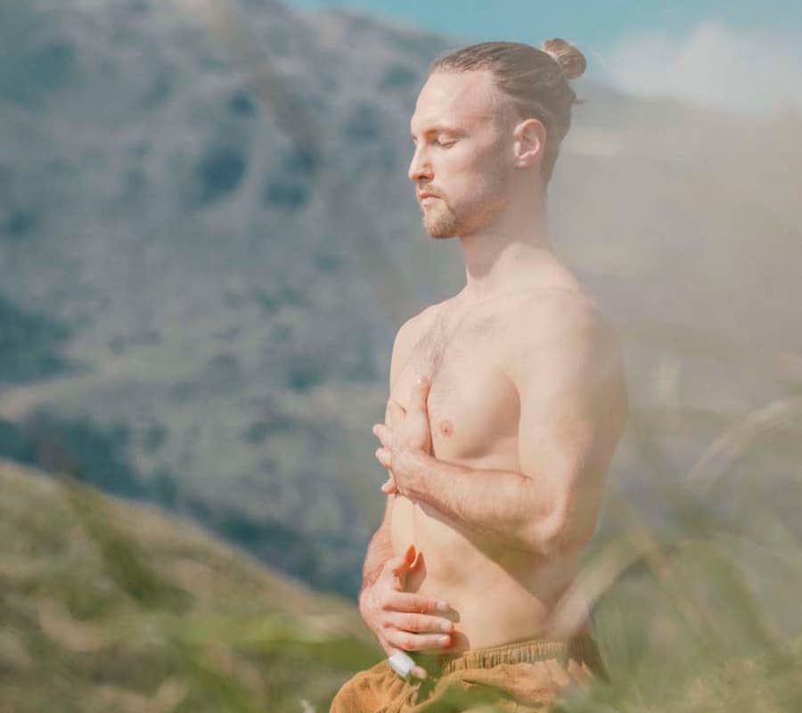 Man Meditating In Nature Near Mountains