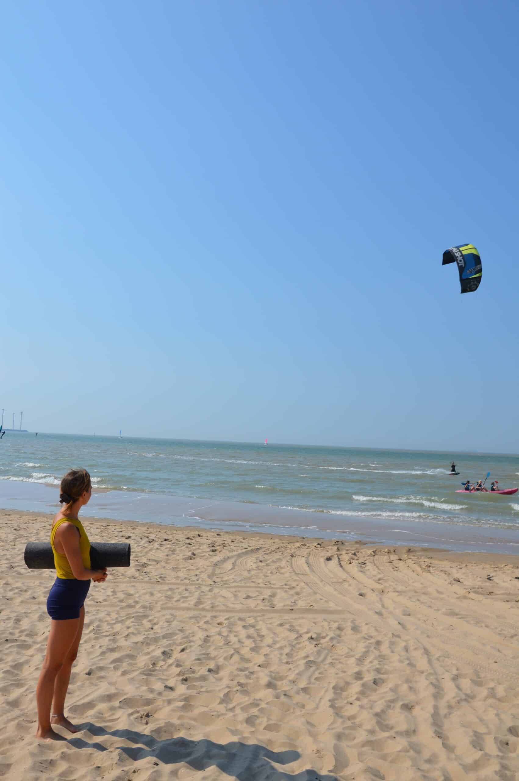 Woman Holding Yoga Mat On Beach