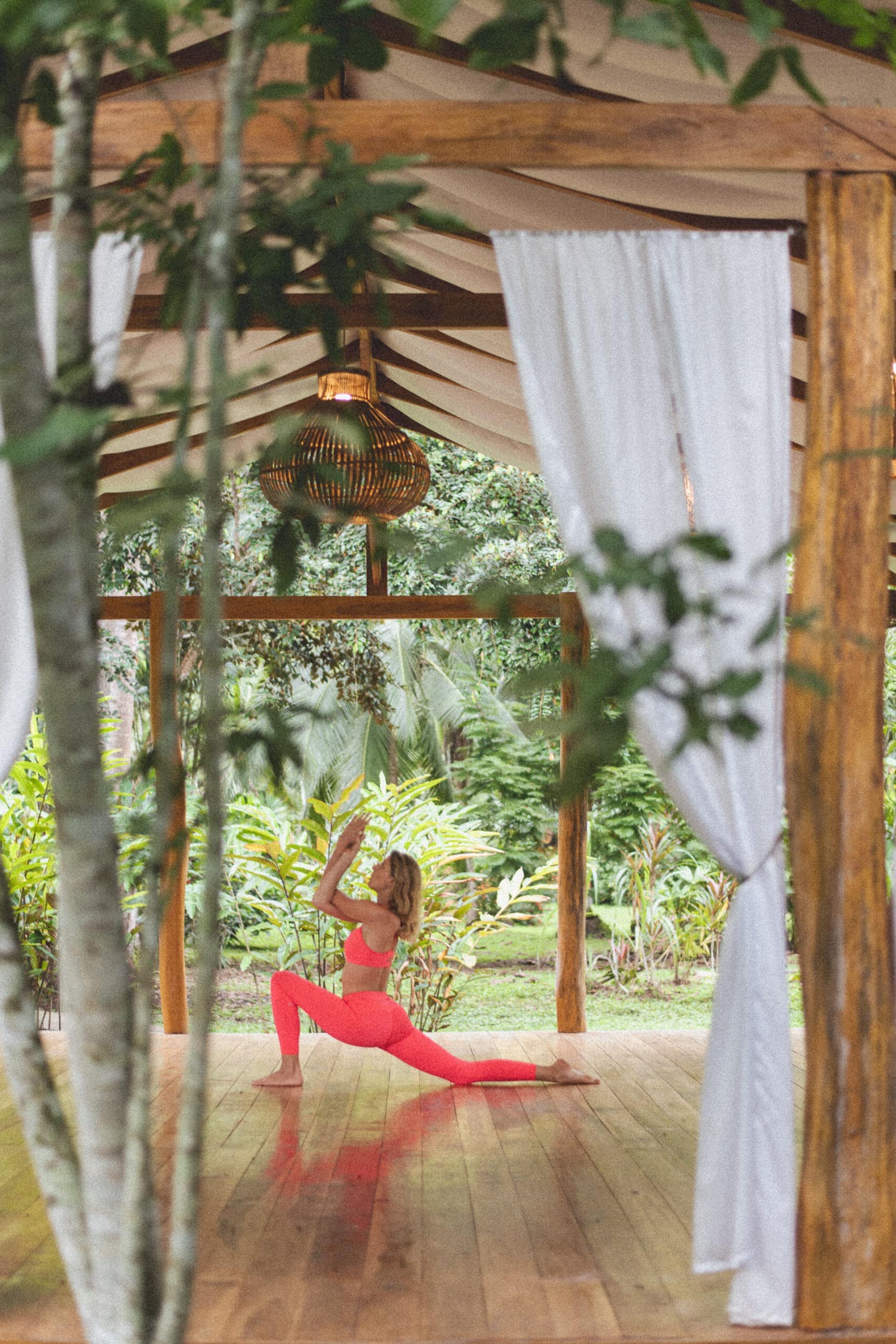 Woman Practicing Yoga in Tropical Pavillion